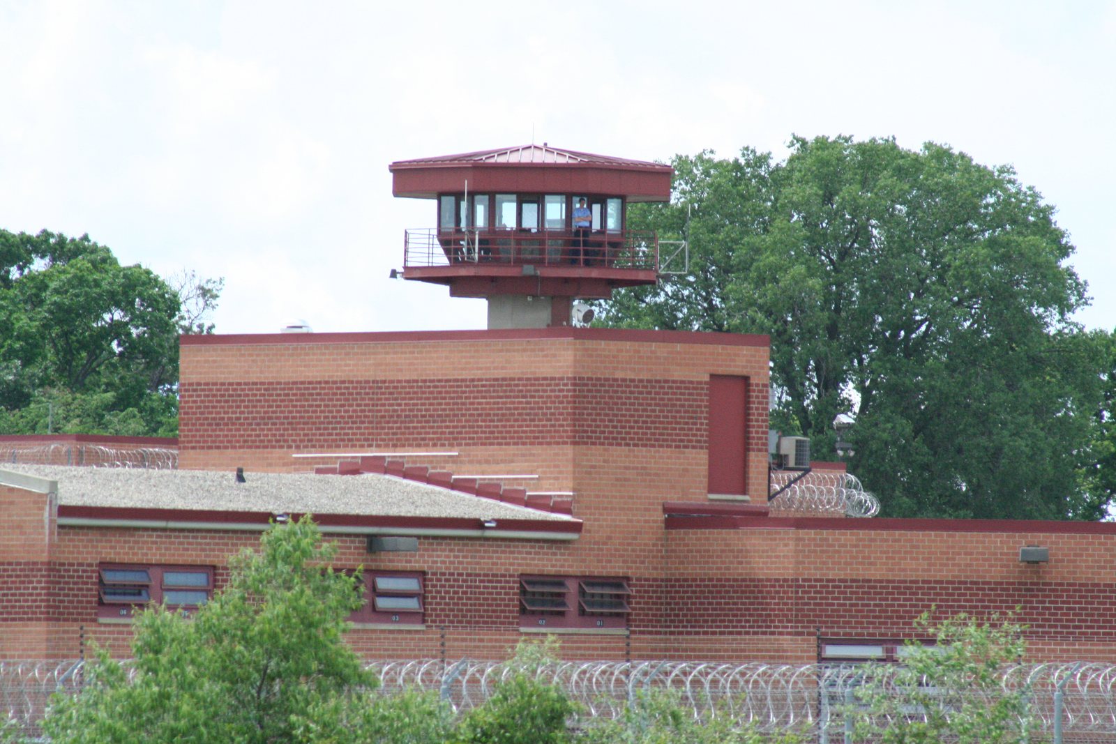 The guard tower and red-brick walls of Columbia Correctional Institution in Portage, Wisconsin, behind coils of razor wire.